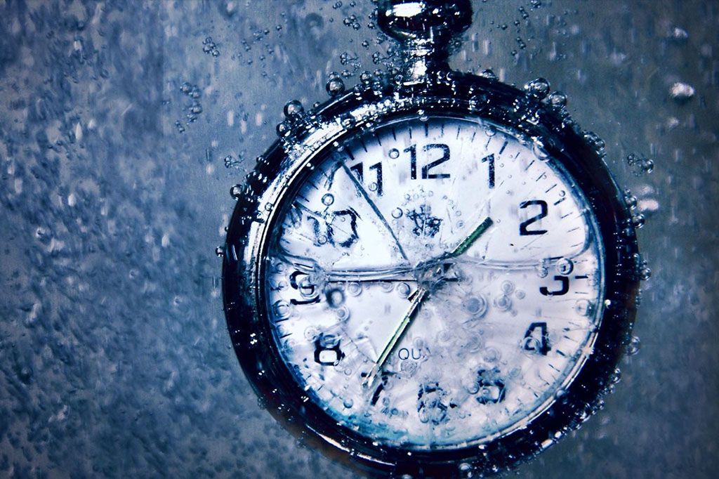 Um relógio tipo cronômetro submerso todo suado para representar horas líquidas de estudos